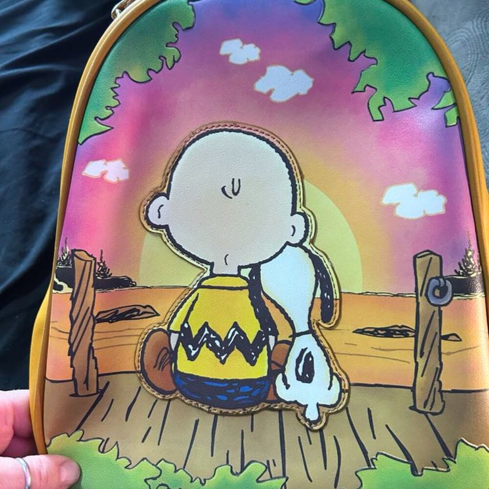 Loungefly Happiness is a warm puppy back pack. Charlie Brown and Snoopy.